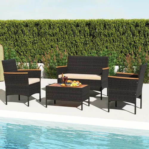 4-piece wicker patio set with two armchairs, a loveseat, and a rectangular coffee table. Features dark wicker with light-colored cushions and wooden accents on the armrests, set beside a pool with a background of tall green hedges.