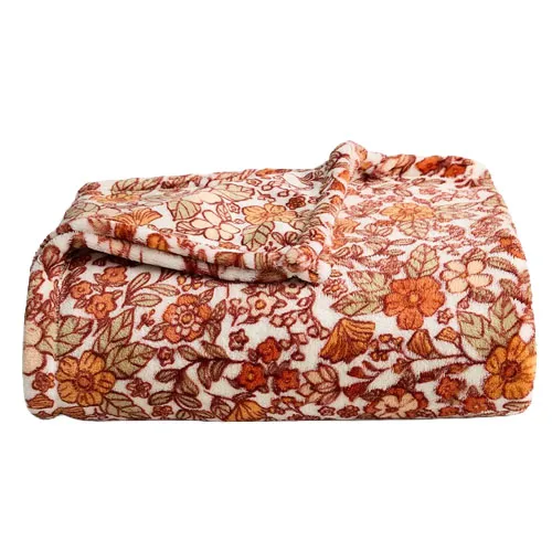 A folded, floral-patterned blanket in shades of orange, brown, and green on a white background.