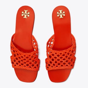 A pair of bright orange sandals with a crisscrossed, netted design on the upper part and a flat sole.