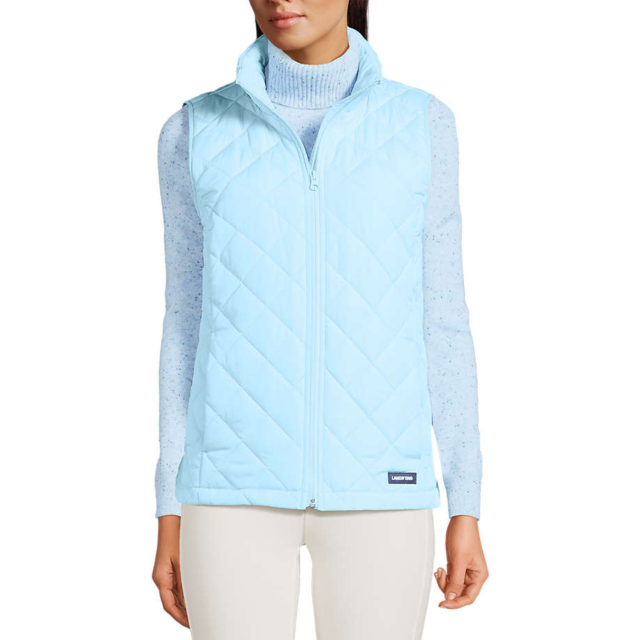 A light blue quilted vest designed for women, featuring a front zipper and high collar, layered over a speckled long-sleeve turtleneck.