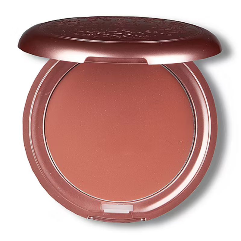 Round compact with a terracotta-colored blush inside, featuring a slightly raised lid pattern.