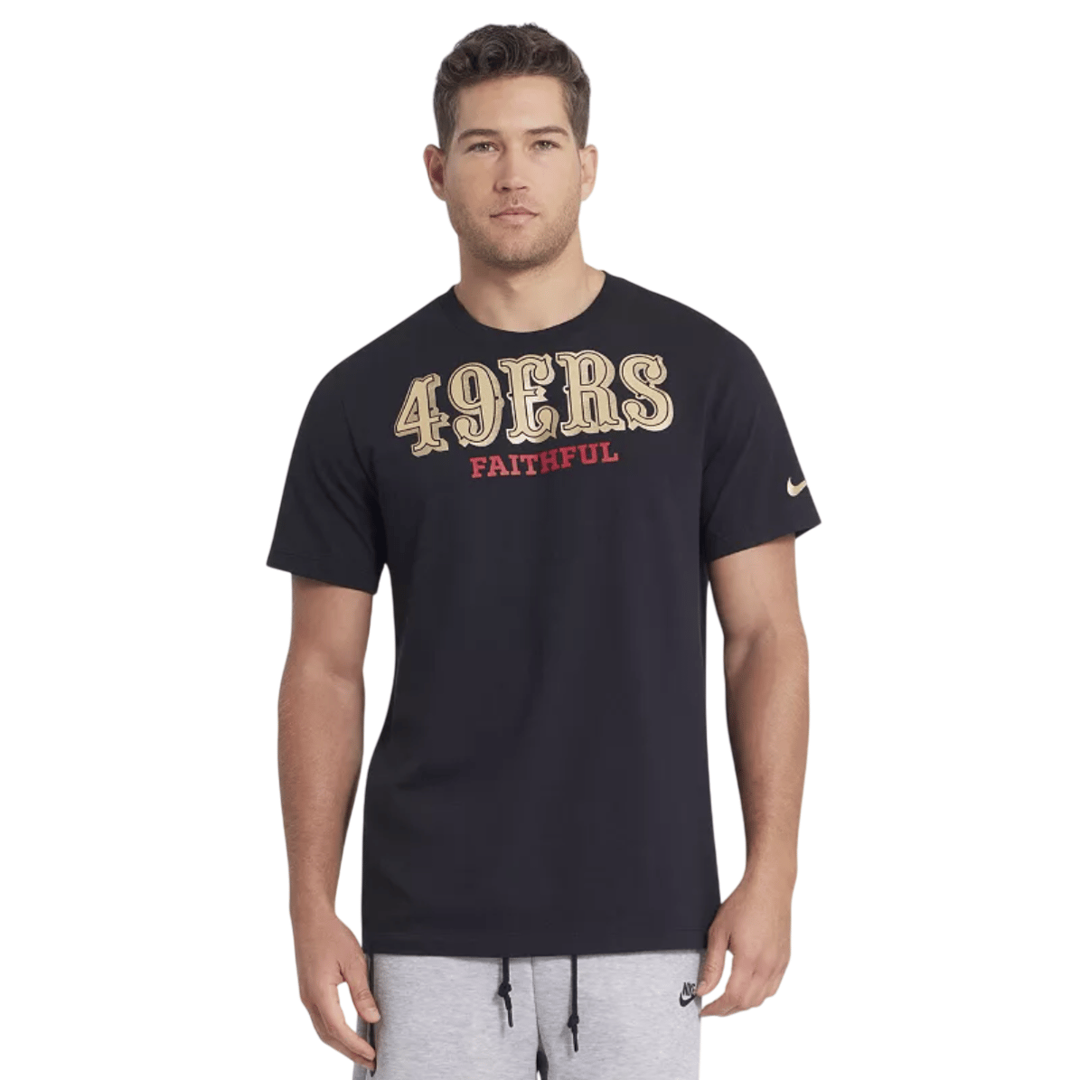 A man wearing a black Nike T-shirt featuring \“49ERS FAITHFUL\“ in gold and red lettering, paired with light grey Nike sweatpants.