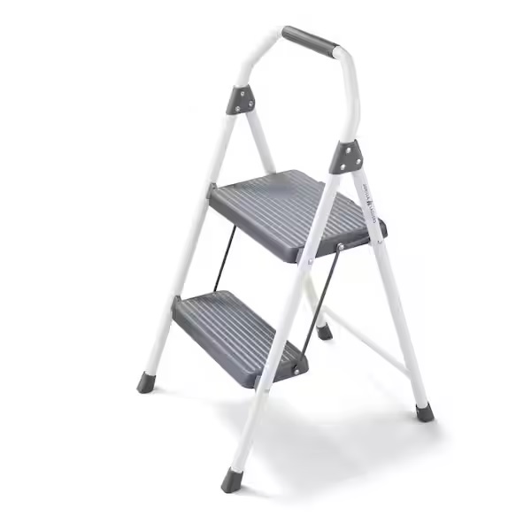 A white two-step ladder with gray, non-slip steps and a padded handle for stability.