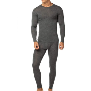 A man is wearing a dark gray long-sleeve thermal underwear set, consisting of a fitted top and matching leggings, ideal for cold weather layering.