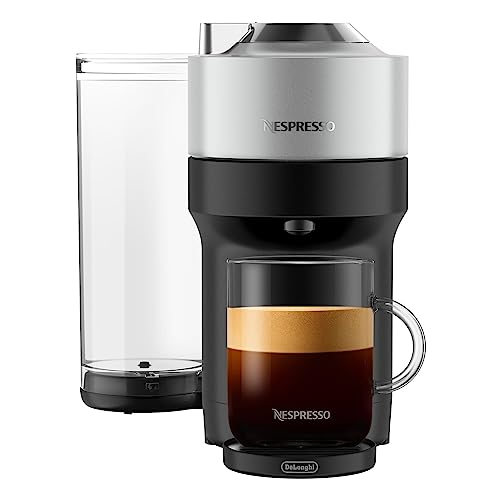 A Nespresso VertuoPop+ Deluxe Machine with a sleek, modern design, featuring a water tank on the left and a cup of coffee with a rich crema on the right.