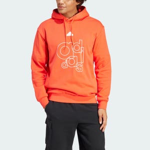 A person wearing a bright orange hoodie with a stylized brand logo and black cargo pants.