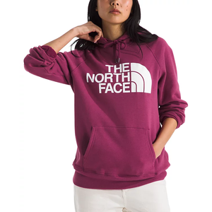 A person wears a maroon hoodie with a large white \“The North Face\“ logo, paired with white pants.