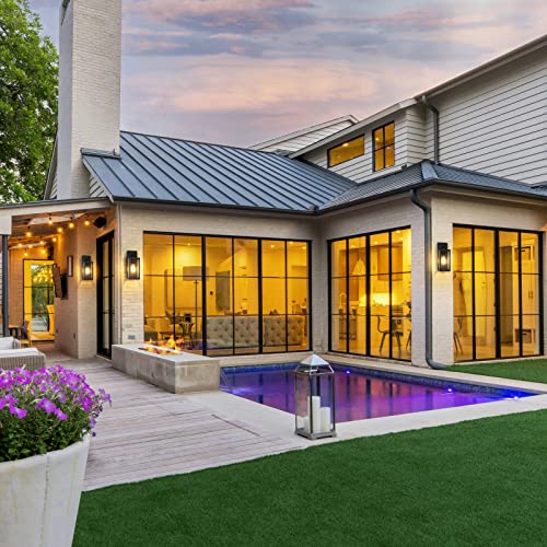 Two outdoor wall lights with a modern design featuring clean lines and a warm glow, mounted on a house exterior next to glass doors.