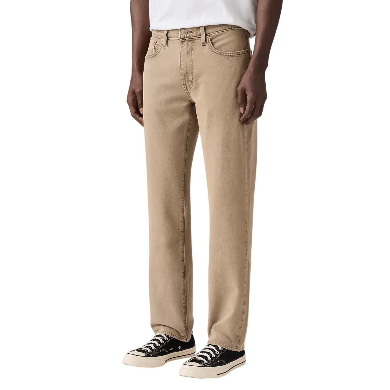 Beige straight-leg jeans paired with black and white canvas sneakers on a male model.