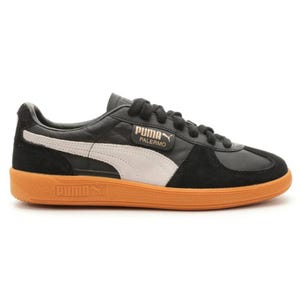 Puma Palermo sneaker in black with a white stripe and orange sole.