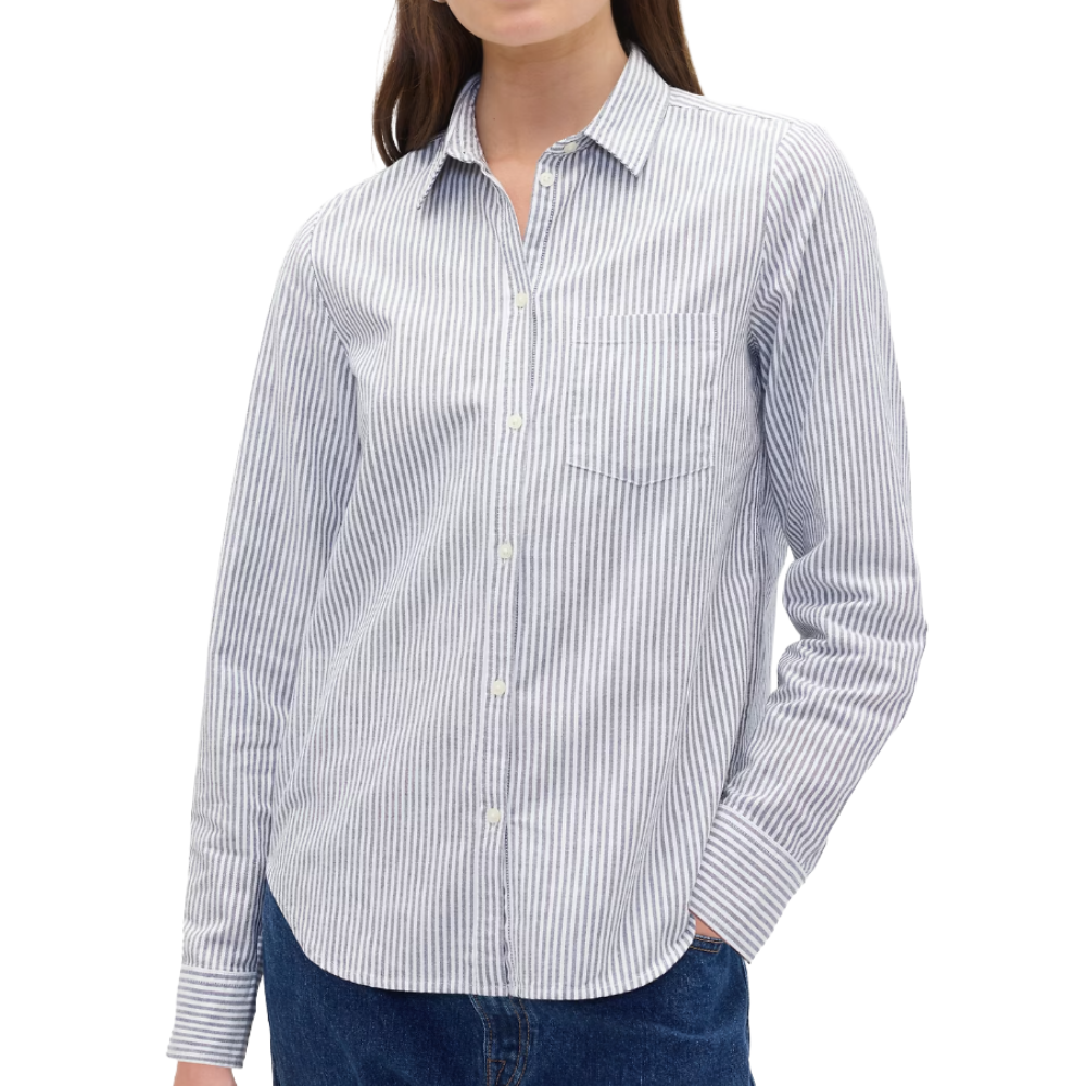 A woman is wearing a long-sleeve, striped button-up shirt with a collar and a chest pocket, paired with blue jeans.