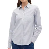 A woman is wearing a long-sleeve, striped button-up shirt with a collar and a chest pocket, paired with blue jeans.