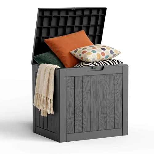 A black storage box with a wood panel design is open, revealing pillows and a folded blanket inside.