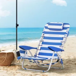 Beach scene with a blue and white striped lounge chair under a white umbrella, next to a woven basket on the sand by the ocean.