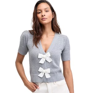 Gray short-sleeve cardigan with a V-neck and textured knit. Features two prominent white bow accents on the front.