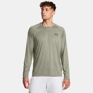 A man is wearing a long-sleeved olive green athletic shirt with a small black logo on the chest.