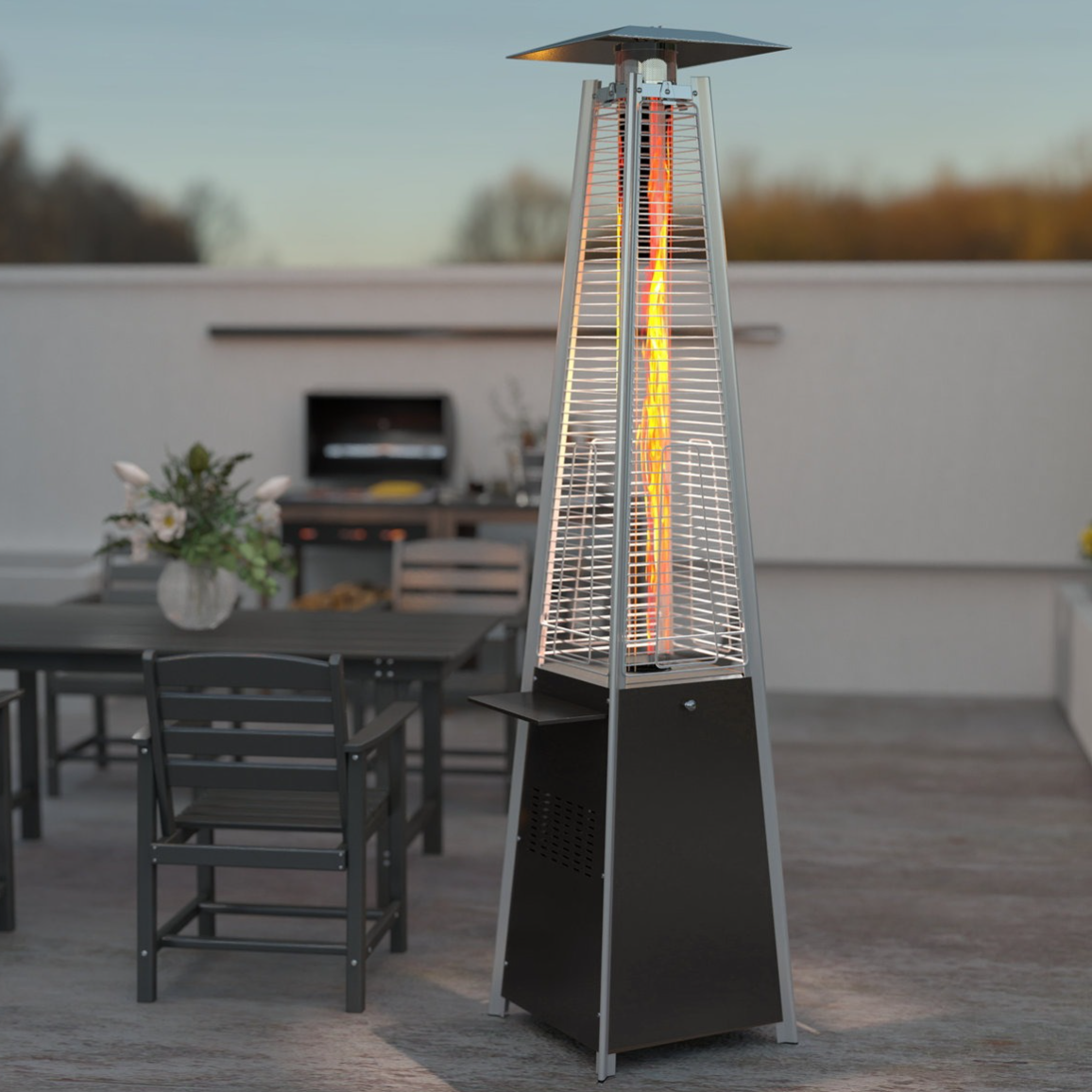 Patio with a pyramid-style outdoor heater beside a table set with chairs and decorative plants, and a grill in the background.