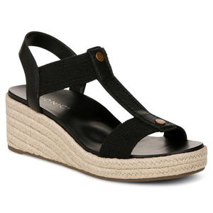 A black wedge sandal with an espadrille sole, featuring a T-strap design and ankle support with a small button embellishment.