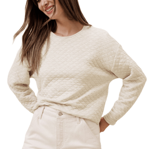 A beige quilted sweater featuring a diamond pattern, long sleeves, and a round neckline, paired with matching light-colored pants.