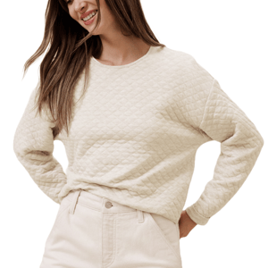 A beige quilted sweater featuring a diamond pattern, long sleeves, and a round neckline, paired with matching light-colored pants.