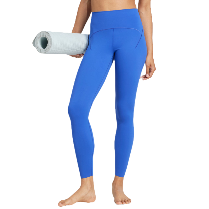 A person is wearing bright blue high-waisted leggings and holding a rolled-up white yoga mat.