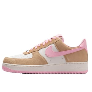 A low-top sneaker featuring a white and tan upper made of suede, accented with a pink swoosh, laces, and sole.