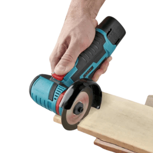 A person is using a handheld, battery-operated mini circular saw to cut through a wooden board, demonstrating its use for precise woodworking tasks.