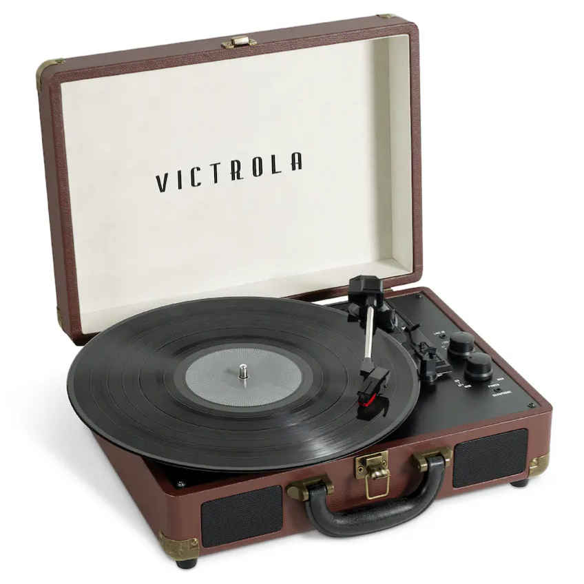Victrola portable suitcase record player with a vinyl record on the turntable, featuring built-in speakers and control knobs.