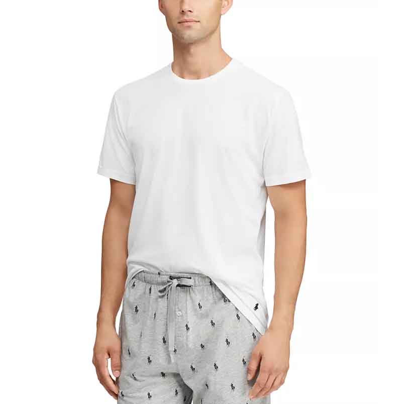 A man models a white, short-sleeve Polo Ralph Lauren cotton sleep shirt paired with drawstring gray pajama pants featuring a small polo player pattern.