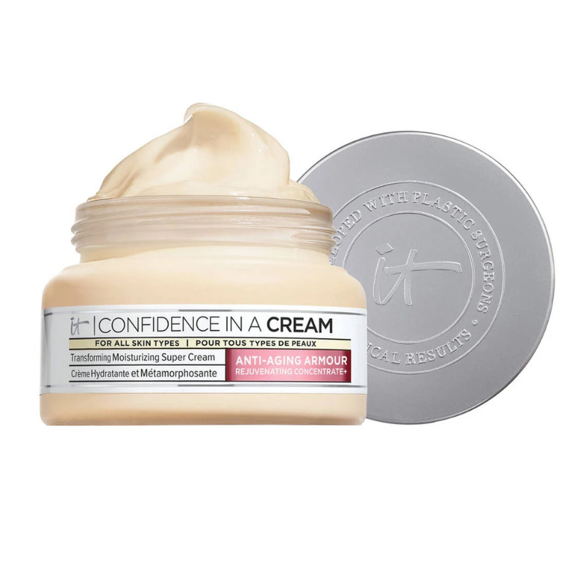 A jar of IT Cosmetics Confidence in a Cream anti-aging moisturizer is pictured with its cream exposed next to its open silver lid.