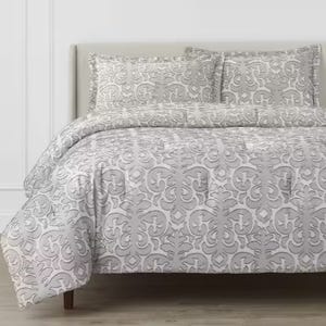 Gray and white patterned bedding set including a duvet cover and pillowcases on a bed.