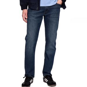 Men's straight fit jeans in medium dark wash, featuring a classic five-pocket style and paired with black and white athletic shoes.