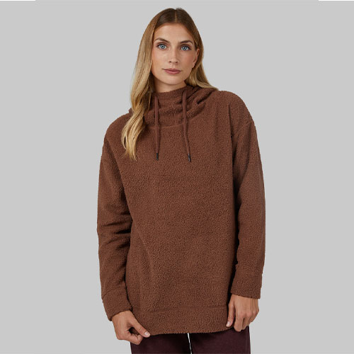 A woman wears a brown sherpa hoodie with long sleeves and a hood with drawstrings.