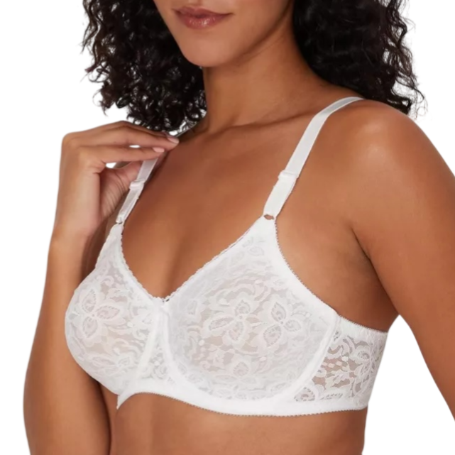 A woman is wearing a white lace underwire bra with adjustable straps.