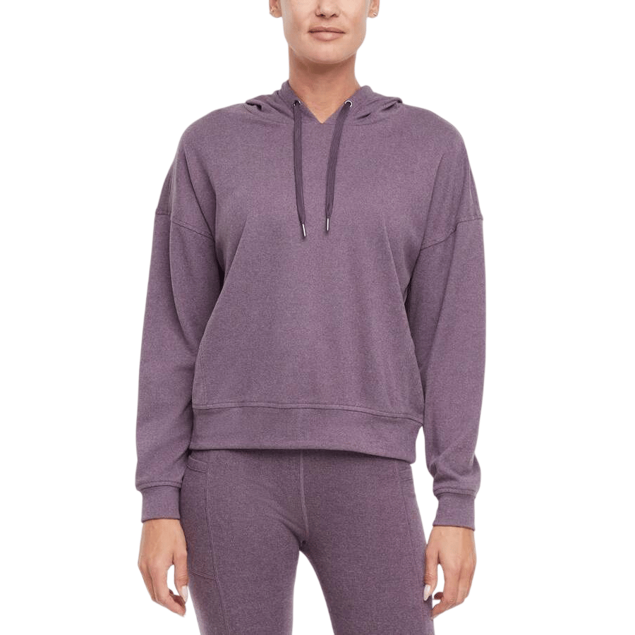A person is wearing a purple hooded sweatshirt and matching leggings.