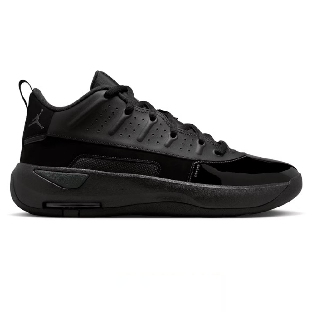 A black athletic sneaker featuring a low-top design, perforated detailing, and the Jumpman logo on the heel.