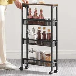 A compact rolling storage cart featuring three-tiered mesh shelves, containing bottles, spices, utensils in a container, and jars, ideal for kitchen organization. It has a metal frame, a wooden top, and four wheels for easy mobility.