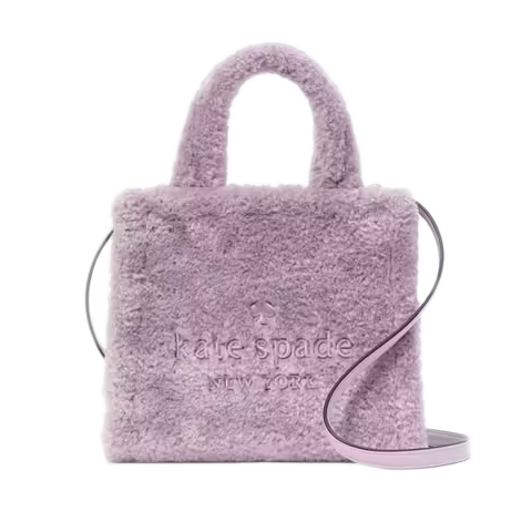 A lavender faux-fur tote with top handles and a shoulder strap, featuring \“kate spade new york\“ embossed on the front.