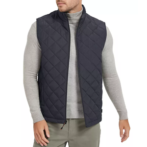 A man is wearing a gray turtleneck sweater and a quilted navy blue vest.