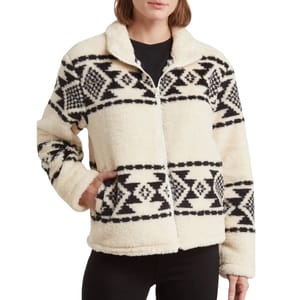 A women's faux fur zip jacket with a soft, cream-colored base featuring a black geometric print design. The jacket has a cozy collar, side pockets, and long sleeves, offering a warm and stylish look.