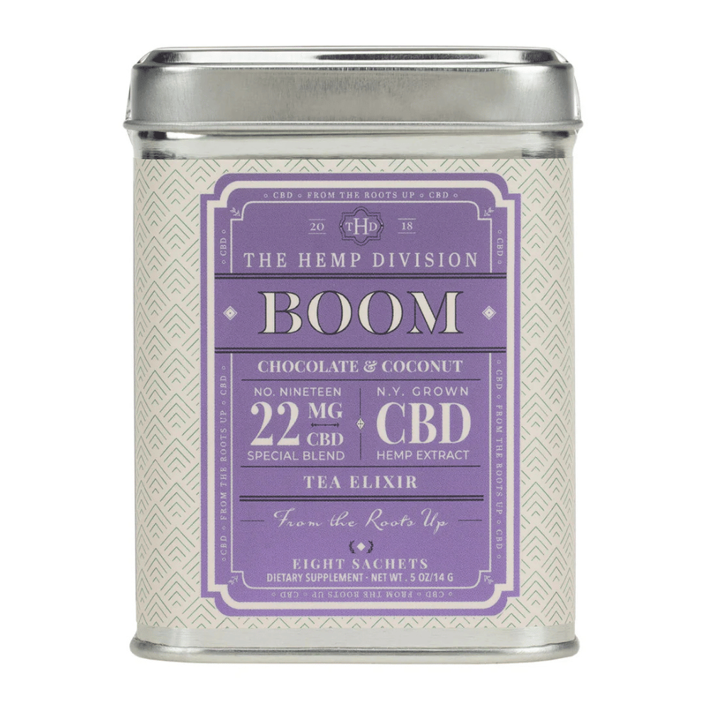 A tin of \“BOOM\“ tea elixir from The Hemp Division, featuring a chocolate and coconut flavor, contains 22 mg of CBD per sachet. The package includes eight sachets and is described as a special blend with hemp extract from N.Y.