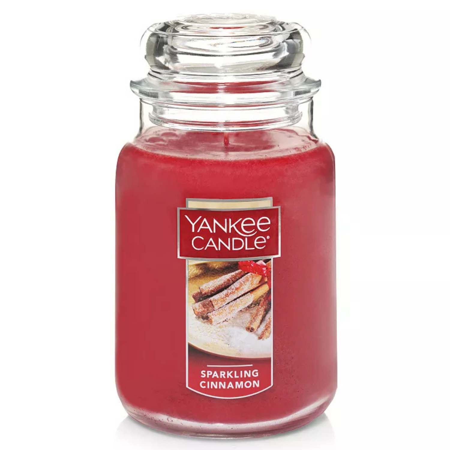A red jar candle labeled \“Yankee Candle\“ with the scent \“Sparkling Cinnamon,\“ featuring a photo of cinnamon sticks on the front.