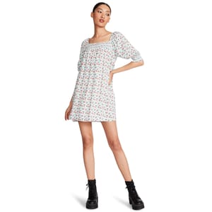 A woman is wearing a floral print dress with three-quarter sleeves and black lace-up boots.