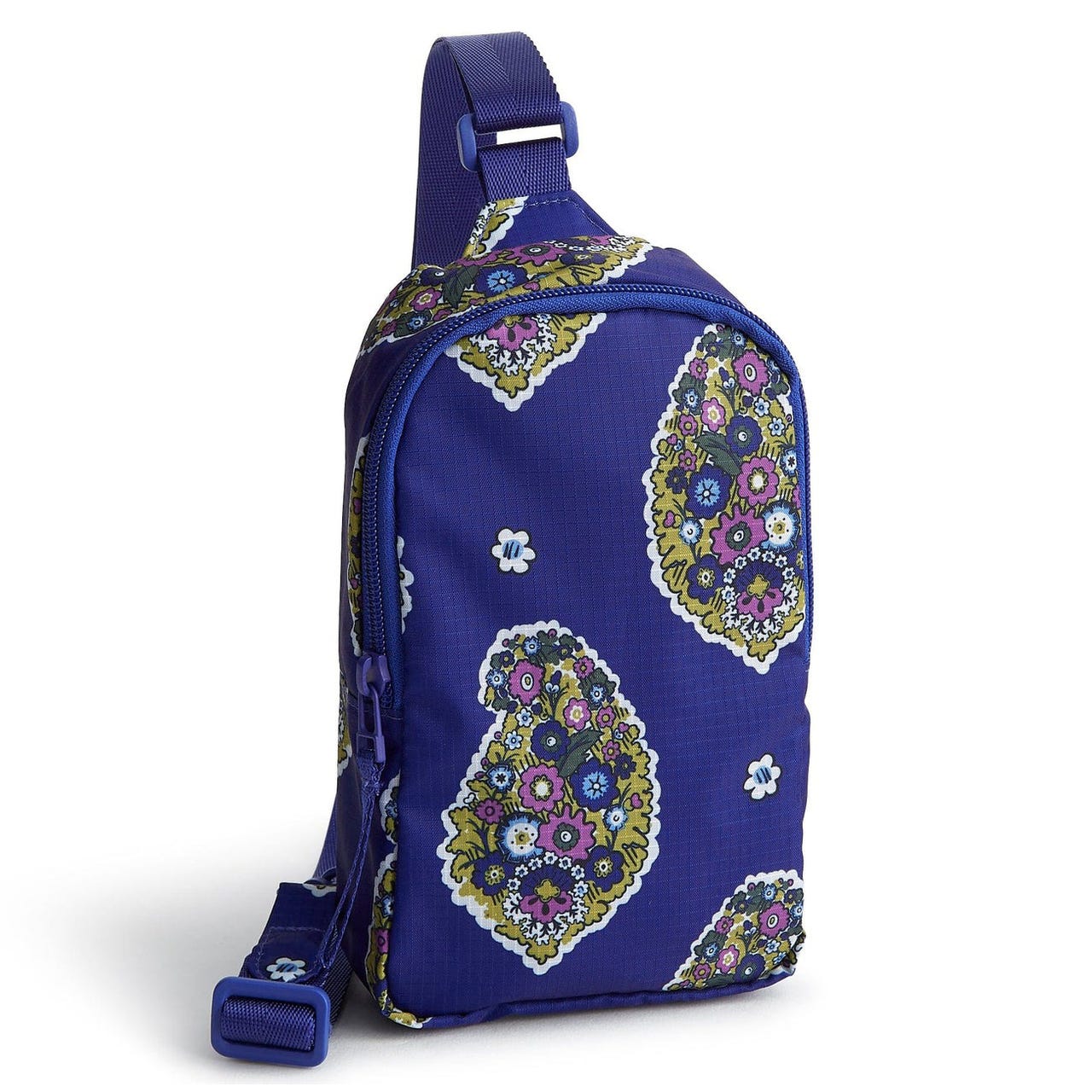 A vibrant blue sling bag with a floral and paisley pattern in purple, green, and white, featuring an adjustable strap and zippered compartment.