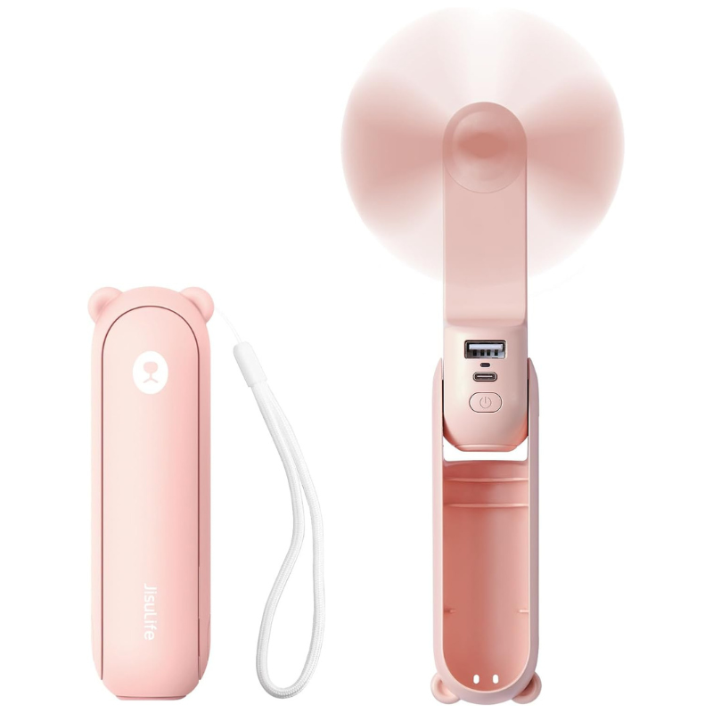 A pink handheld portable fan with a bear-ear design, featuring USB and charging ports, and a wrist strap for easy carrying.