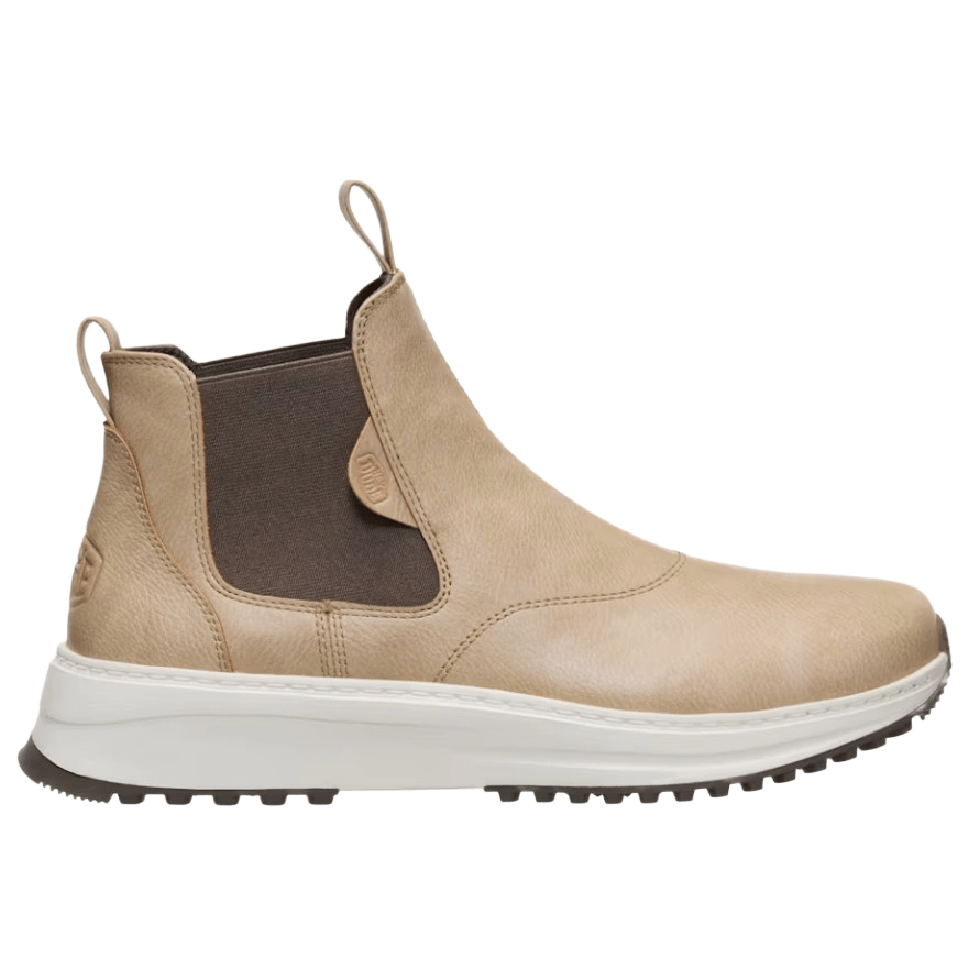 A tan Chelsea boot with pull tabs and a brown elastic side panel, featuring a white sole with black tread.