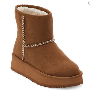 The Arizona Runyon Platform Heel Boots feature a brown suede exterior with distinctive white stitching accents and a plush, fur-lined interior. They have a thick platform sole for added height and stability.