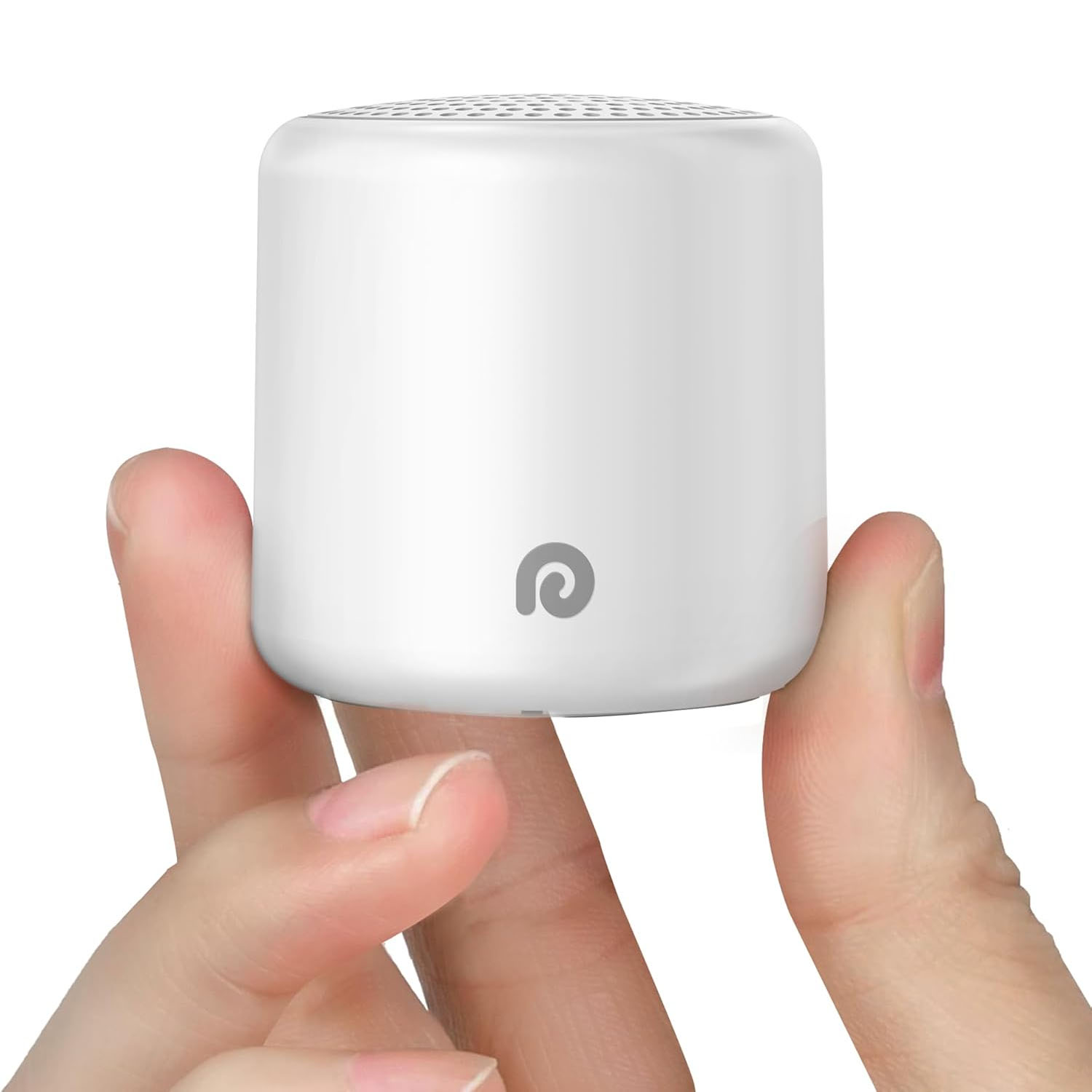 A compact white Bluetooth speaker is held between fingers, featuring a minimalistic design with a small logo on its side.