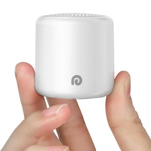 A compact white Bluetooth speaker is held between fingers, featuring a minimalistic design with a small logo on its side.