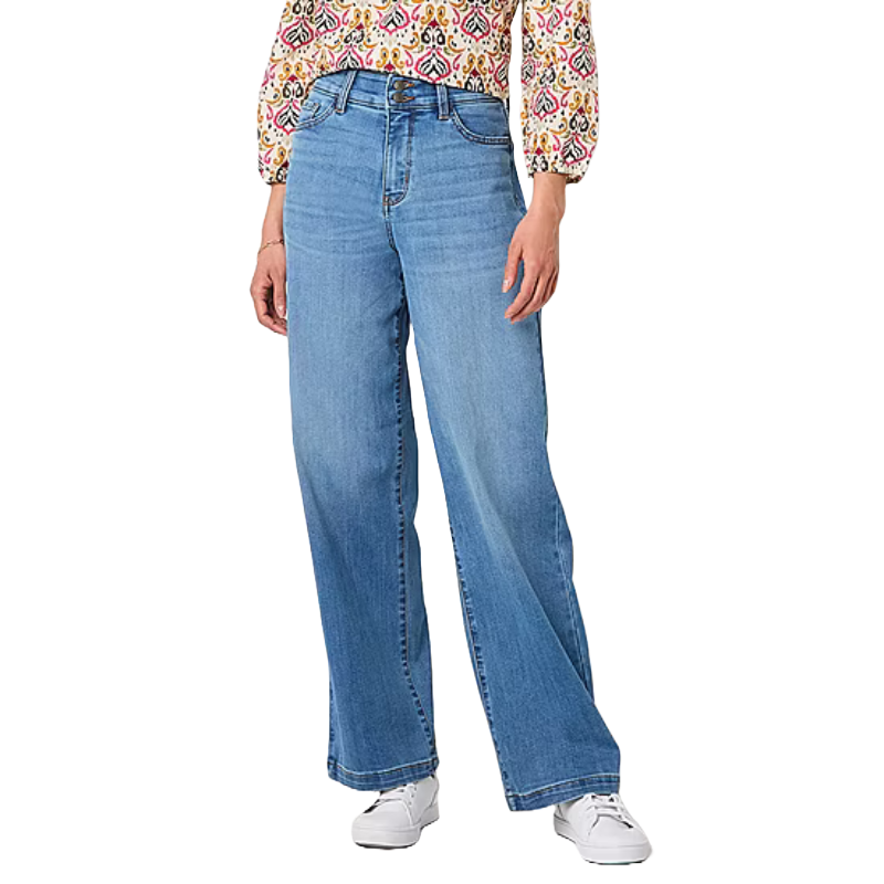 A person is wearing light blue wide-leg jeans paired with white sneakers and a patterned blouse with three-quarter sleeves.